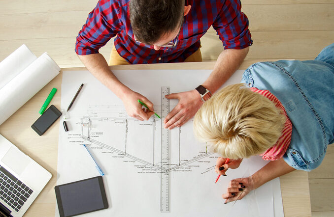 Deux étudiants en Architecture vue de haut, travaillant sur un plan